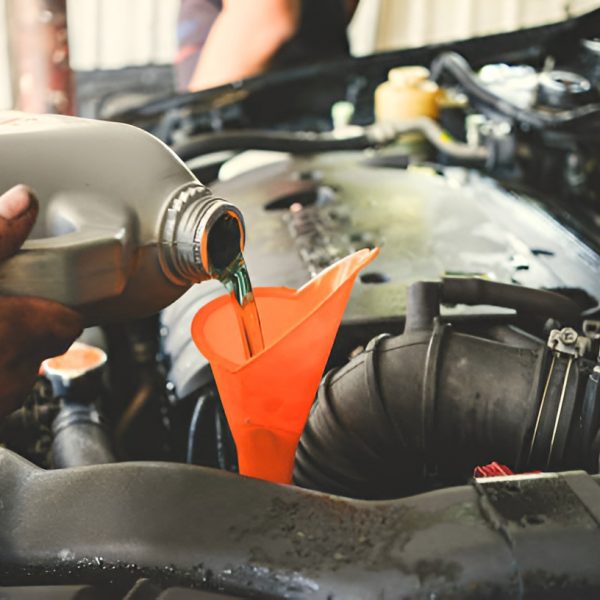 close-up of a man pouring transmission oil