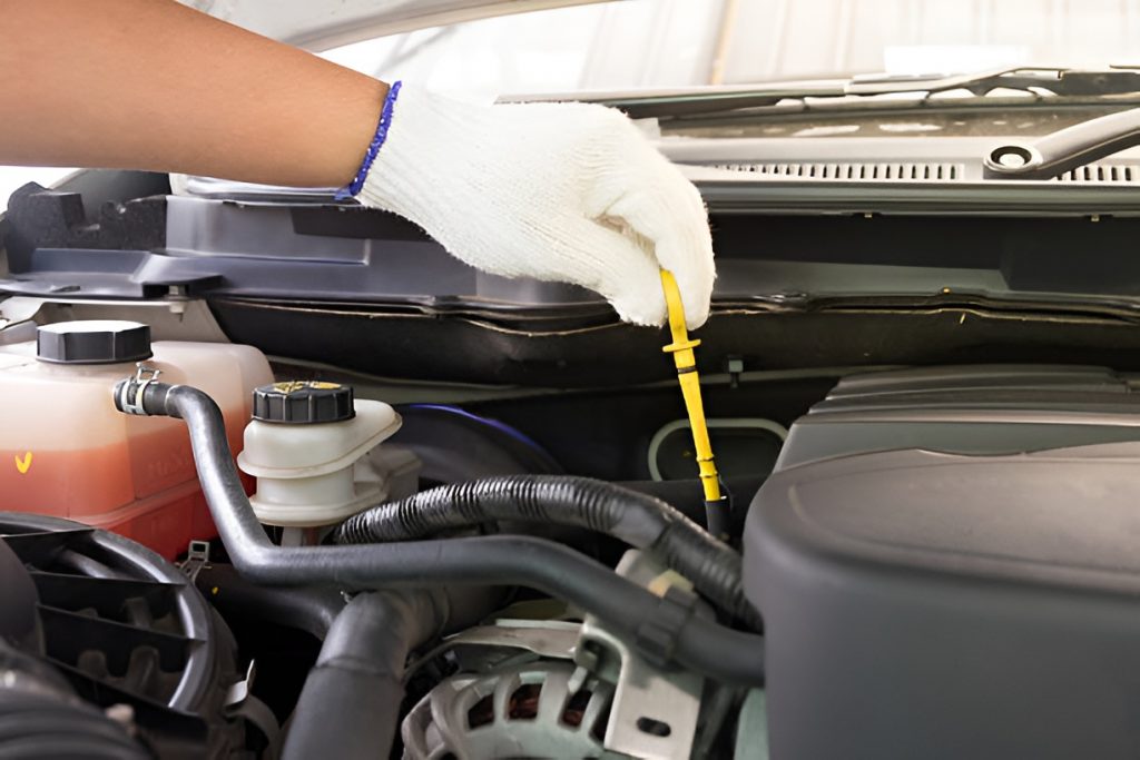 close-up of a man checking a car's transmission fluid level